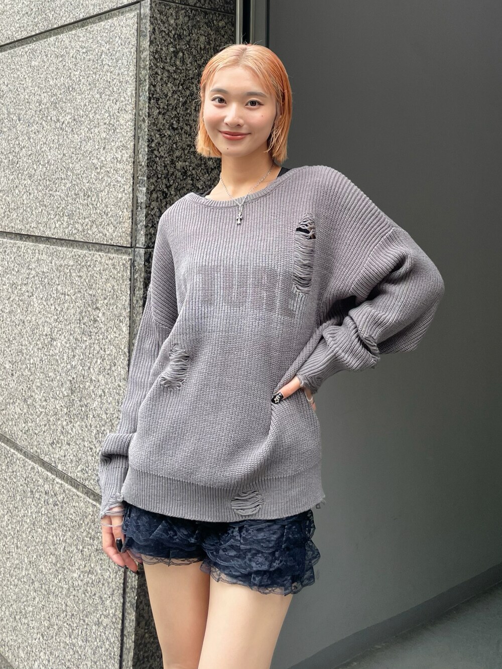 グレー系のニット/セーター、ブルー系のその他パンツ、シルバー系のネックレスを着用したレディースの秋コーディネートの3枚目の写真