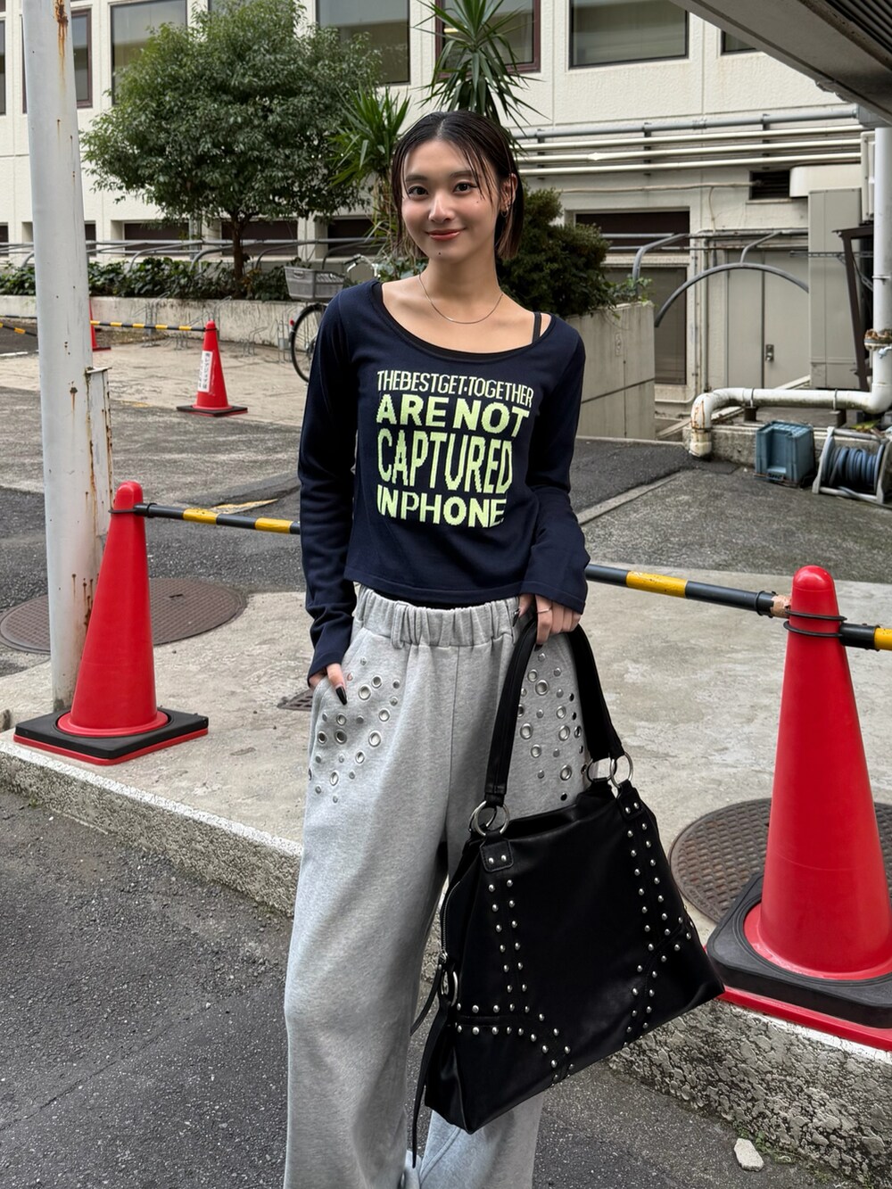 ブルー系のニット/セーター、グレー系のスウェットパンツ、ブラック系のボストンバッグを着用したレディースの冬コーディネートの2枚目の写真