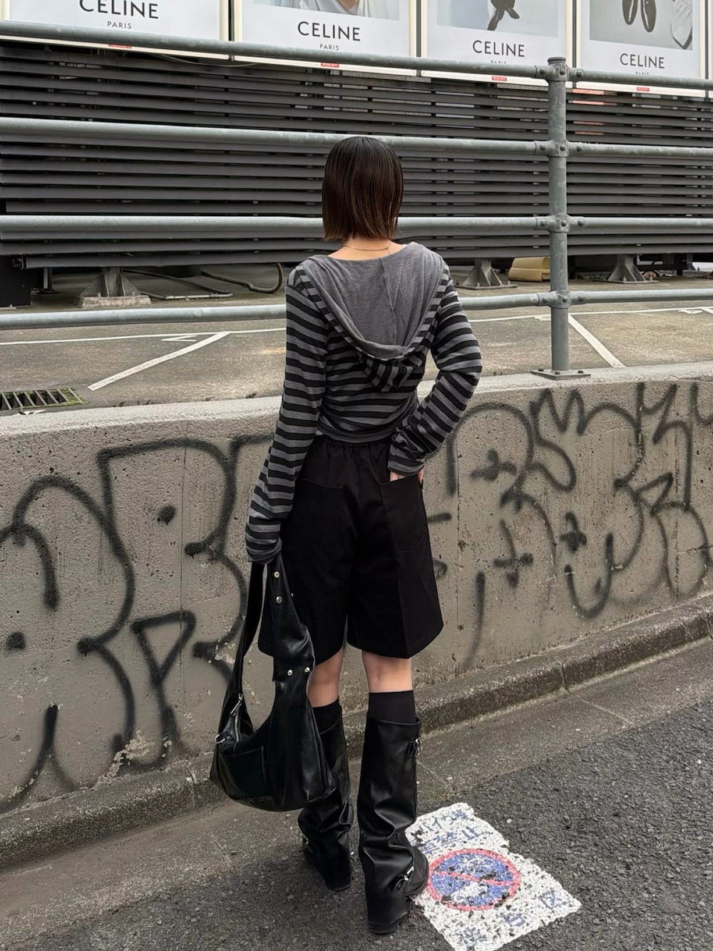 グレー系のパーカー、ホワイト系のキャミソールを着用したレディースの春コーディネートの2枚目の写真