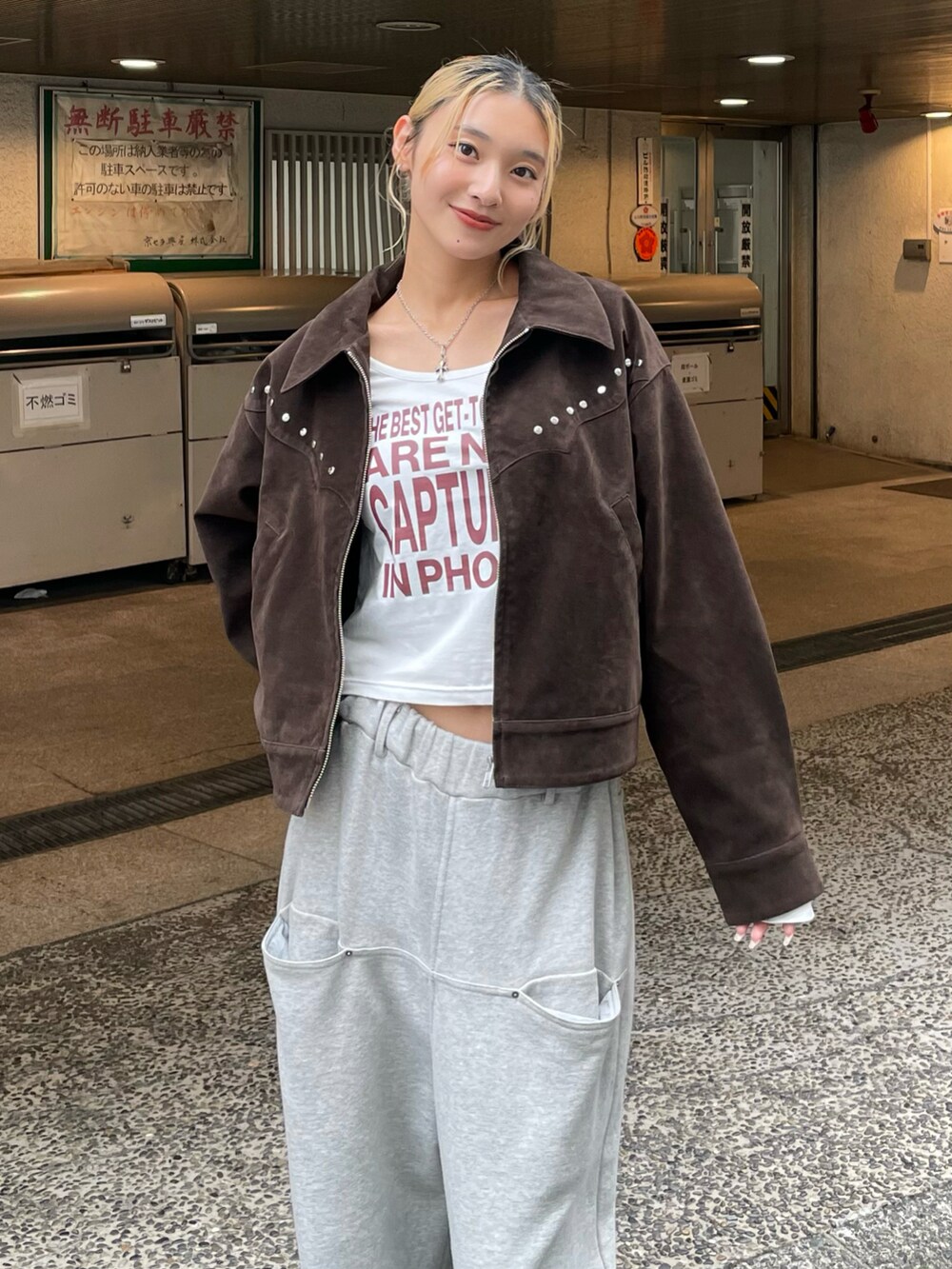 ブラウン系のブルゾン、ホワイト系のTシャツ/カットソー、グレー系のスウェットパンツを着用したレディースの秋コーディネートの4枚目の写真