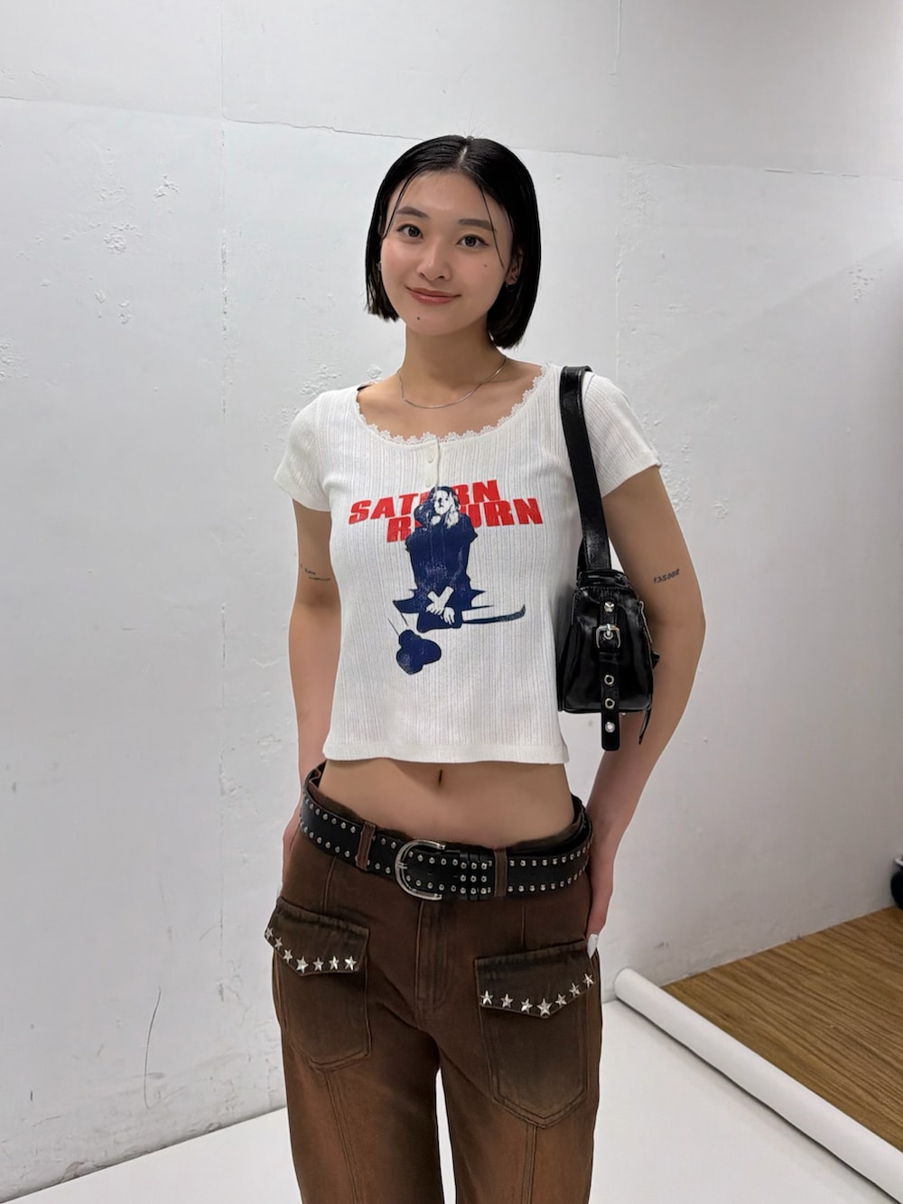 ホワイト系のTシャツ/カットソー、ブラウン系のデニムパンツ、ブラック系のパンプスを着用したレディースの春コーディネートの2枚目の写真