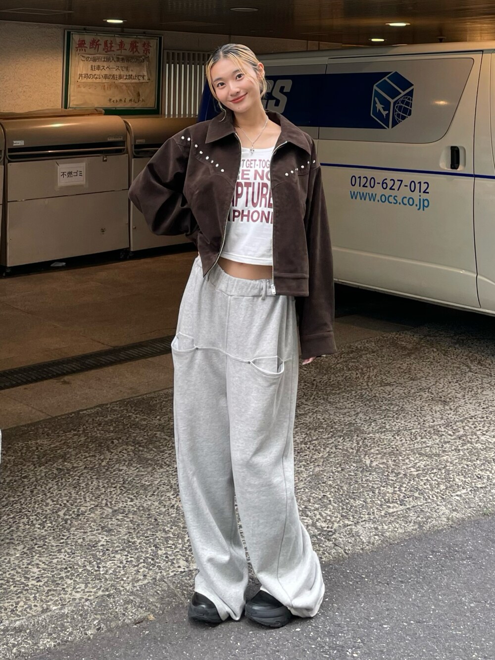 ブラウン系のブルゾン、ホワイト系のTシャツ/カットソー、グレー系のスウェットパンツを着用したレディースの秋コーディネートの2枚目の写真
