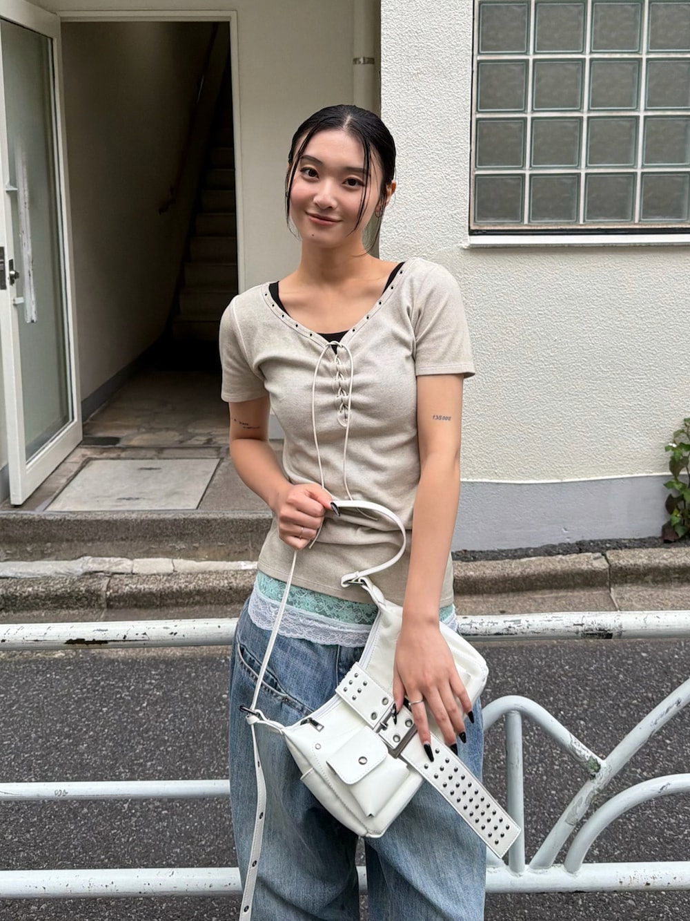 ブルー系のデニムパンツ、ブラック系のパンプス、ホワイト系のTシャツ/カットソーを着用したレディースの夏コーディネートの2枚目の写真