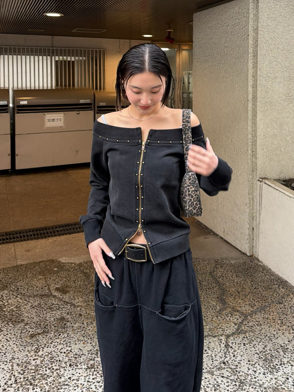 グレー系のTシャツ/カットソー、ブラウン系のショルダーバッグ、ブラック系のスウェットパンツを着用したレディースの冬コーディネートの3枚目の写真