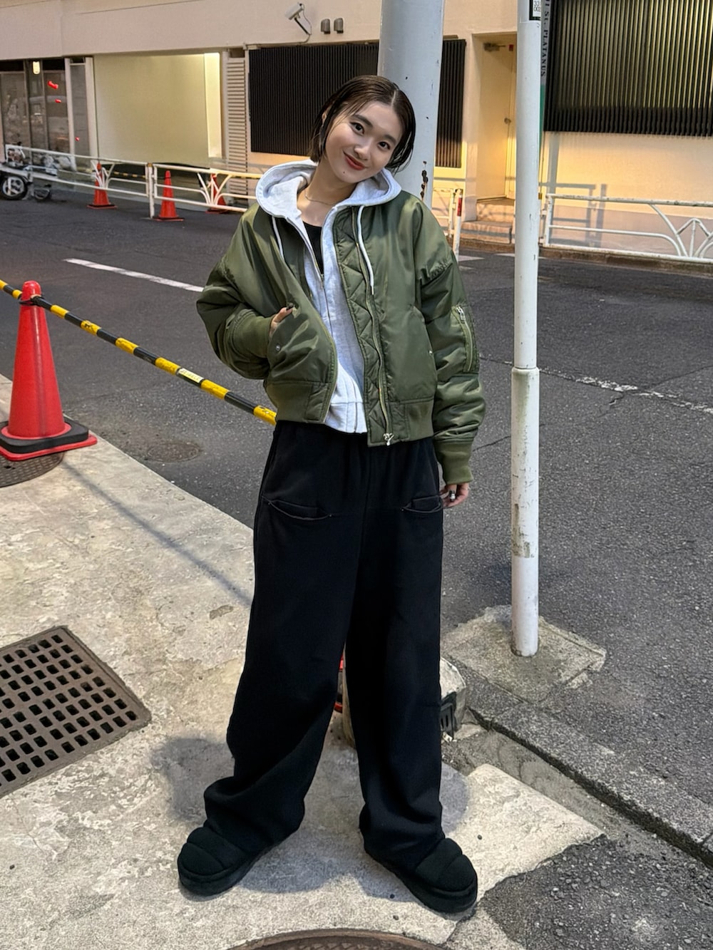 グリーン系のMA-1、ブラック系のスウェットパンツ、グレー系のパーカーを着用したレディースの秋コーディネートの2枚目の写真