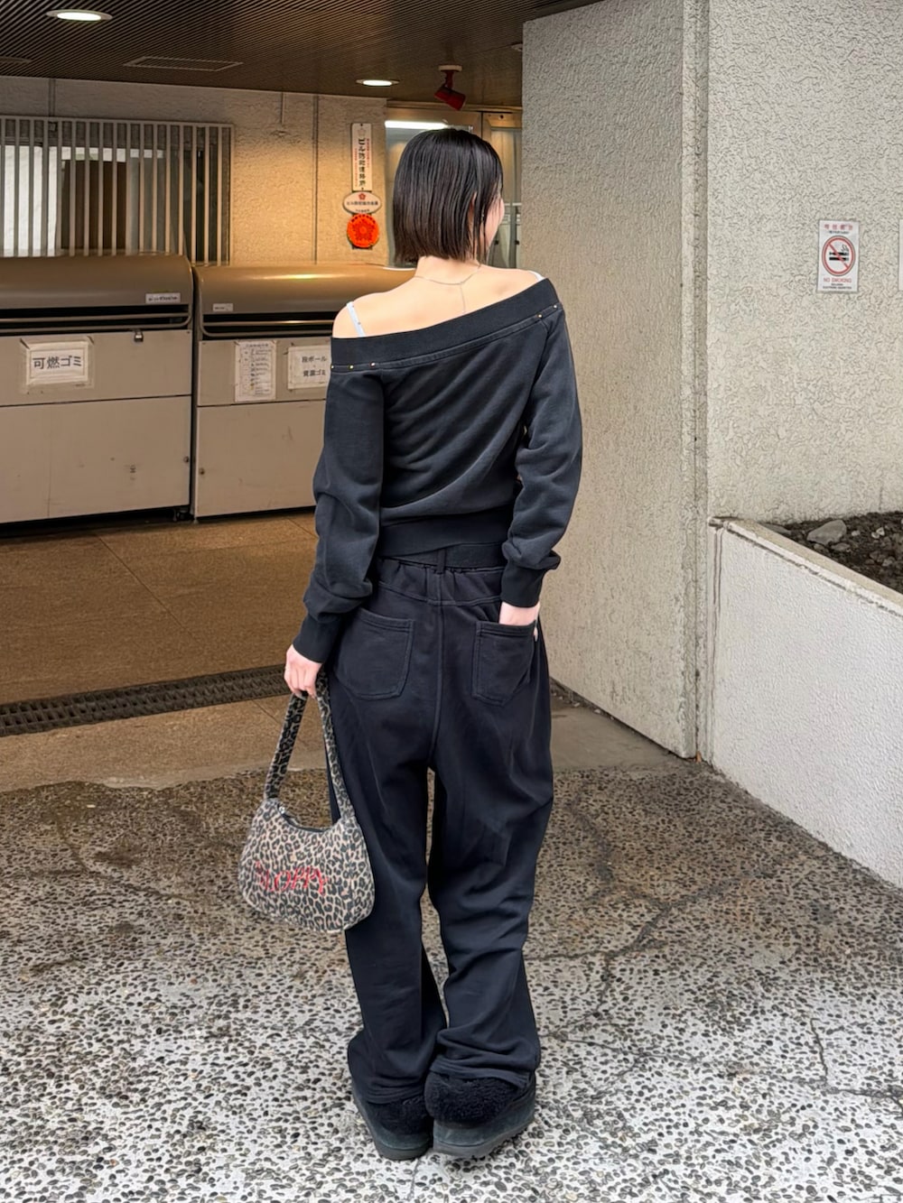 グレー系のTシャツ/カットソー、ブラウン系のショルダーバッグ、ブラック系のスウェットパンツを着用したレディースの冬コーディネートの2枚目の写真