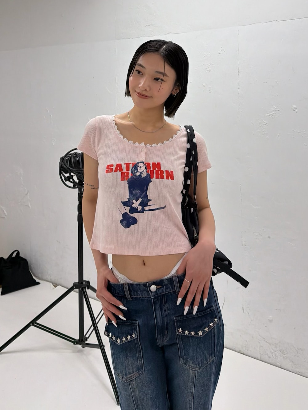 ピンク系のTシャツ/カットソー、ブルー系のデニムパンツ、ホワイト系のパンプスを着用したレディースの春コーディネートの2枚目の写真