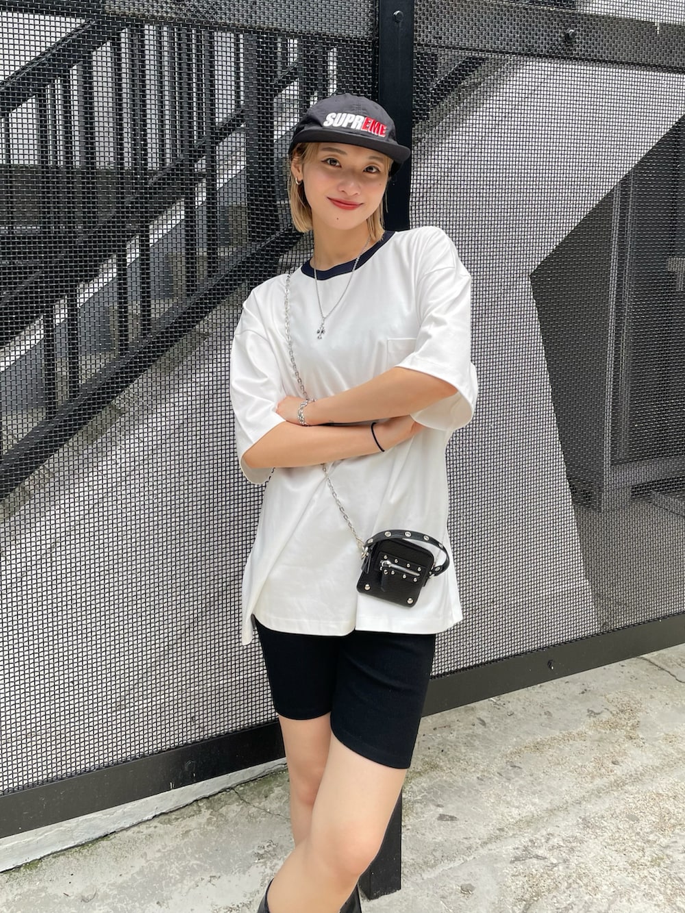 ホワイト系のTシャツ/カットソー、ブラック系のハンドバッグ、シルバー系のネックレスを着用したレディースの夏コーディネートの2枚目の写真