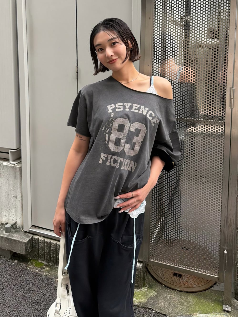 グレー系のTシャツ/カットソー、ブルー系のキャミソール、ホワイト系のショルダーバッグを着用したレディースの夏コーディネートの2枚目の写真