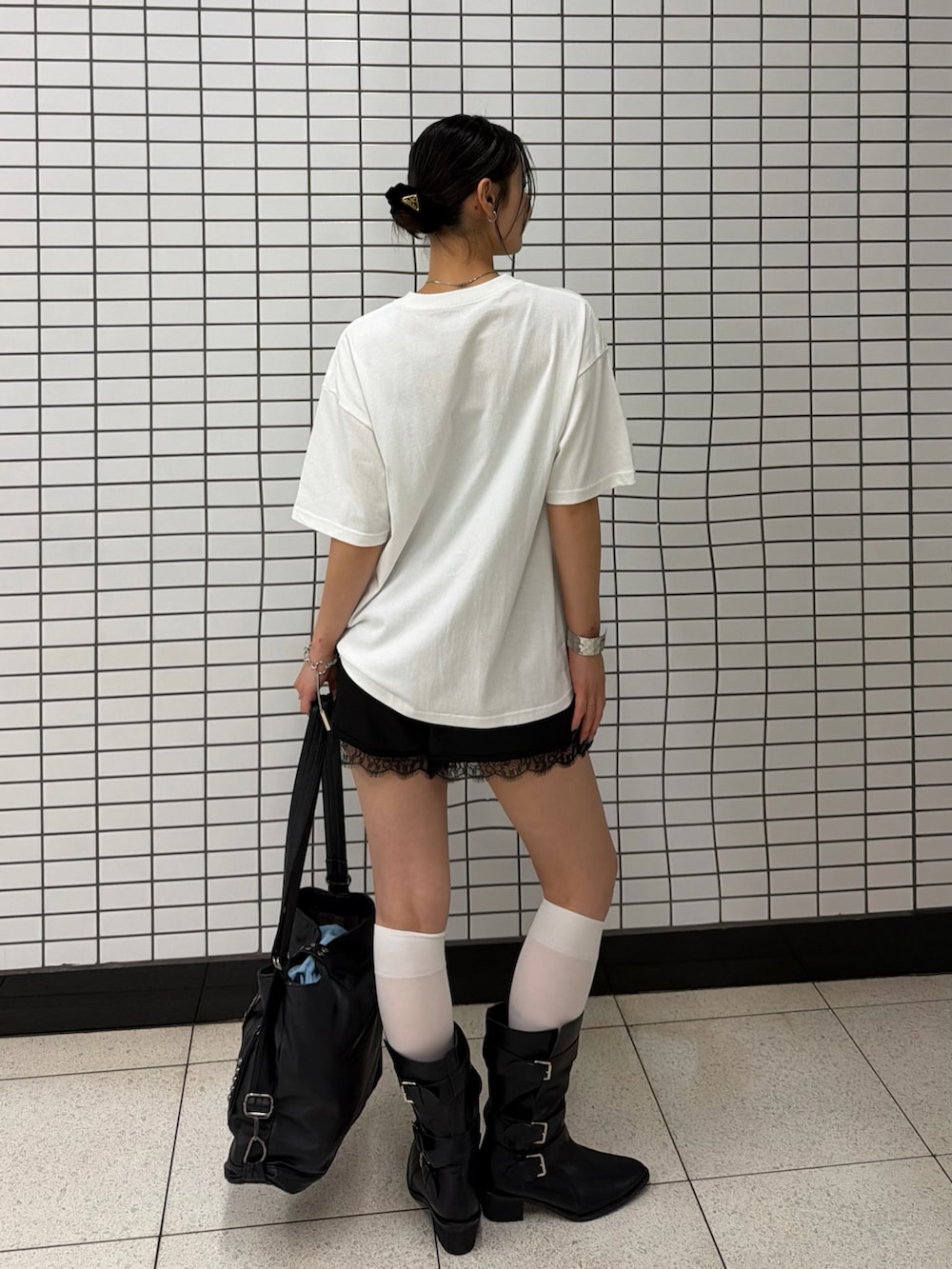 ホワイト系のTシャツ/カットソー、ブラック系のブーツ、ブラック系のショルダーバッグを着用したレディースの夏コーディネートの2枚目の写真