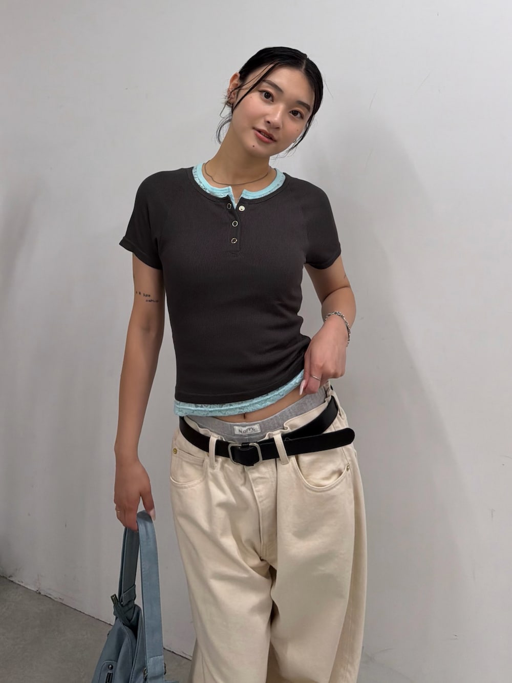グレー系のTシャツ/カットソー、ブルー系のショルダーバッグ、ホワイト系のデニムパンツを着用したレディースの夏コーディネートの2枚目の写真
