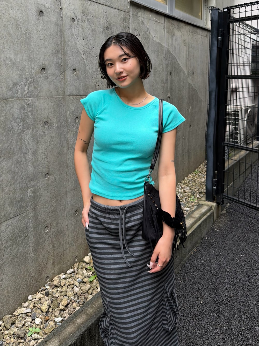 ブルー系のTシャツ/カットソー、ブラック系のショルダーバッグ、ブラック系のパンプスを着用したレディースの夏コーディネートの3枚目の写真