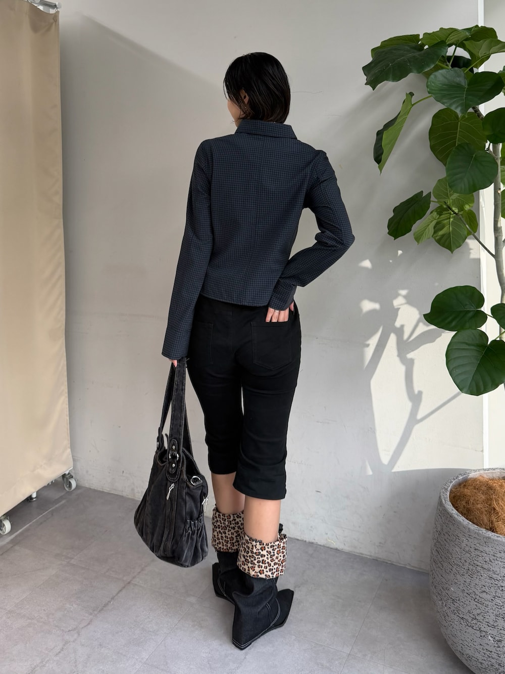 ブラック系のショルダーバッグ、ブルー系のシャツ/ブラウス、ブラック系のブーツを着用したレディースの夏コーディネートの2枚目の写真