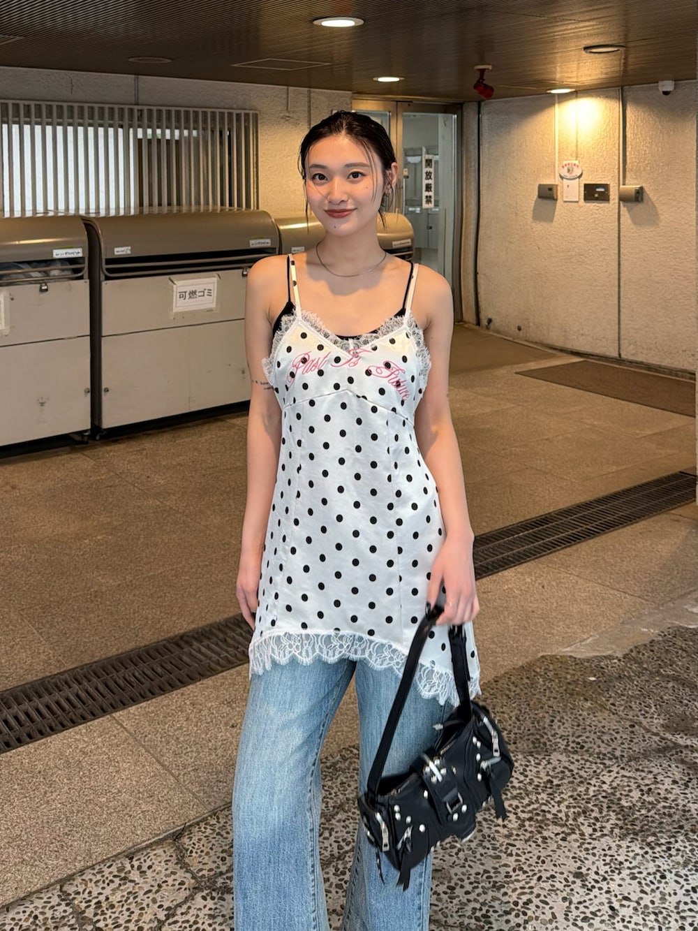 ホワイト系のワンピース、ブラック系のショルダーバッグ、ブルー系のデニムパンツを着用したレディースの春コーディネートの2枚目の写真