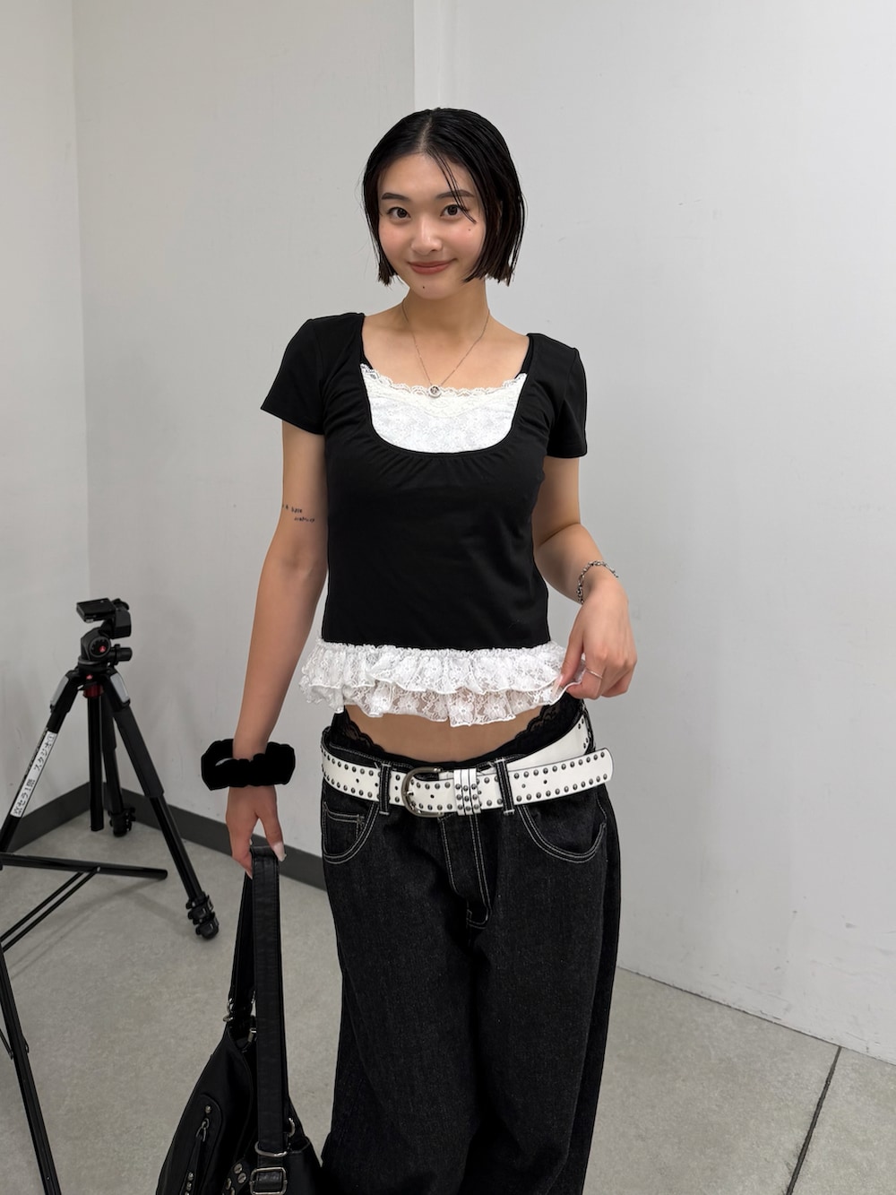 ブラック系のTシャツ/カットソー、ブラック系のデニムパンツ、ブラック系のショルダーバッグを着用したレディースの夏コーディネートの2枚目の写真