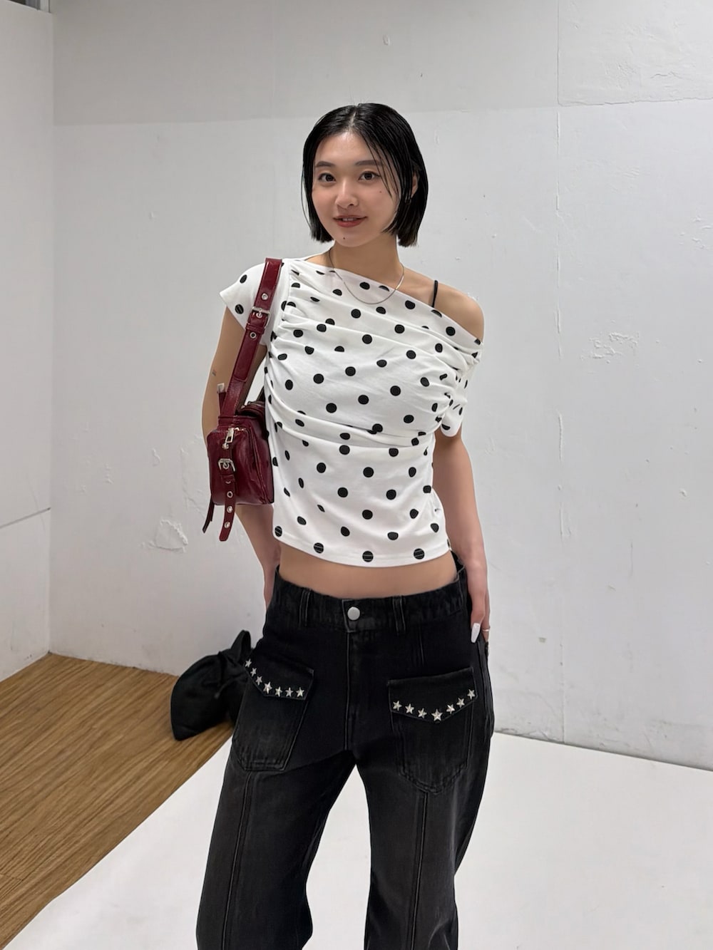 ホワイト系のTシャツ/カットソー、ブラック系のデニムパンツ、レッド系のショルダーバッグを着用したレディースの春コーディネートの3枚目の写真