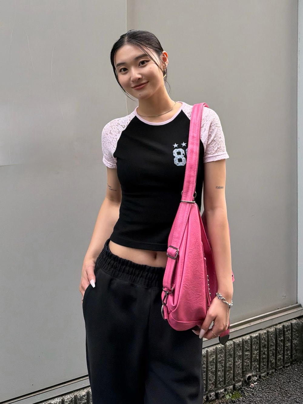 ブラック系のTシャツ/カットソー、ピンク系のショルダーバッグを着用したレディースの夏コーディネートの2枚目の写真