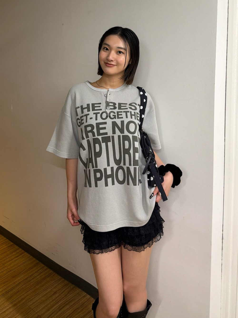 グレー系のTシャツ/カットソー、ブラック系のショルダーバッグ、ブラック系のブーツを着用したレディースの春コーディネートの2枚目の写真