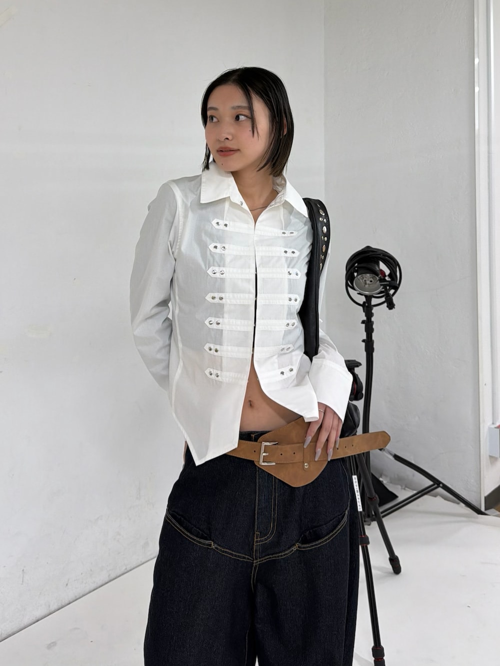 ホワイト系のシャツ/ブラウス、ブルー系のデニムパンツ、ブラック系のショルダーバッグを着用したレディースの冬コーディネートの2枚目の写真