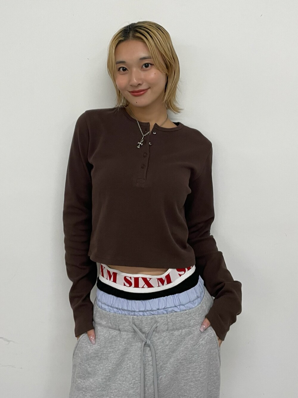 ブラウン系のTシャツ/カットソー、グレー系のパンツ、シルバー系のネックレスを着用したレディースの夏コーディネートの2枚目の写真