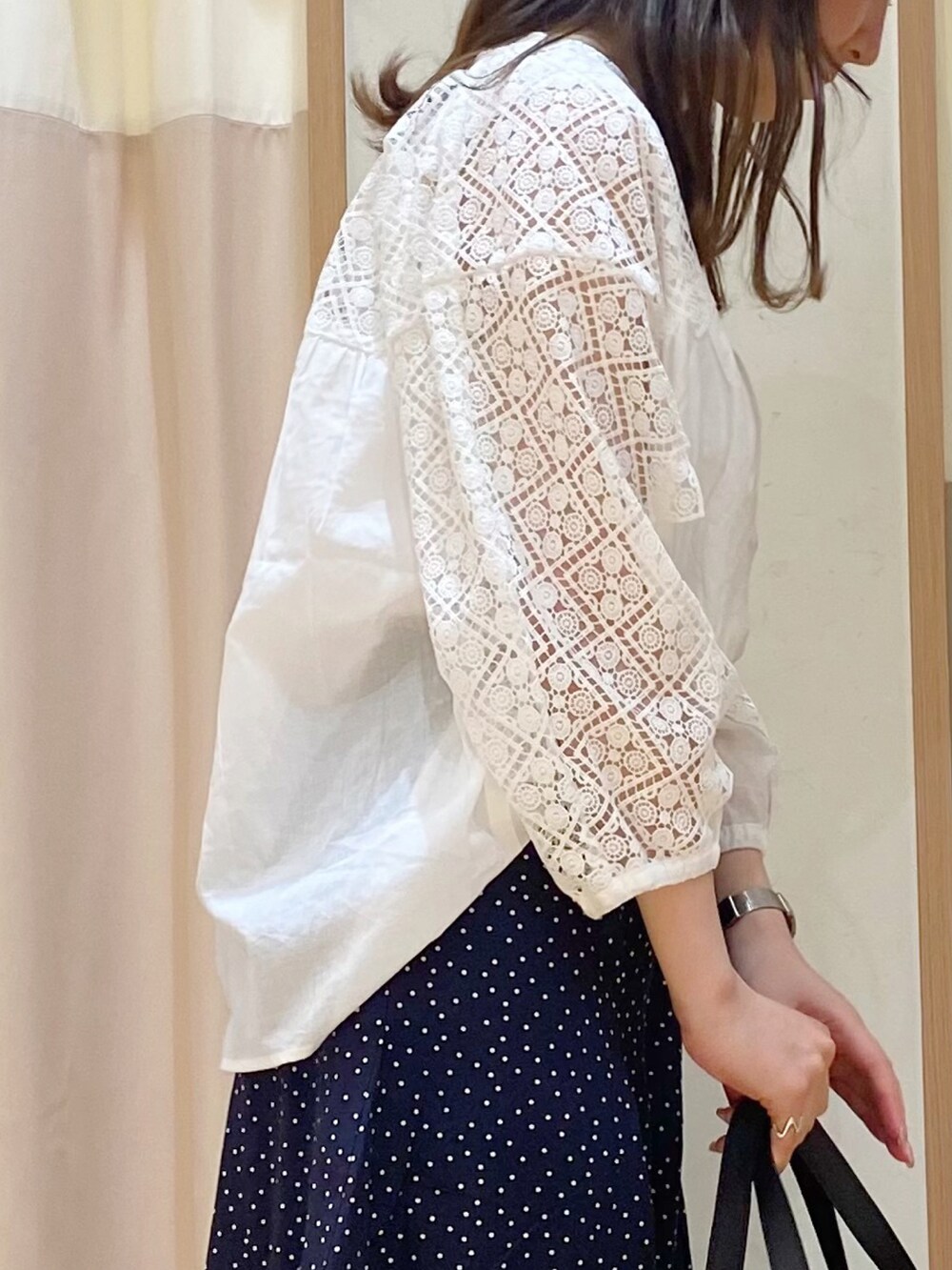 ホワイト系のシャツ/ブラウス、ブラック系のパンツ、ブラック系のハンドバッグを着用したレディースの春コーディネートの2枚目の写真