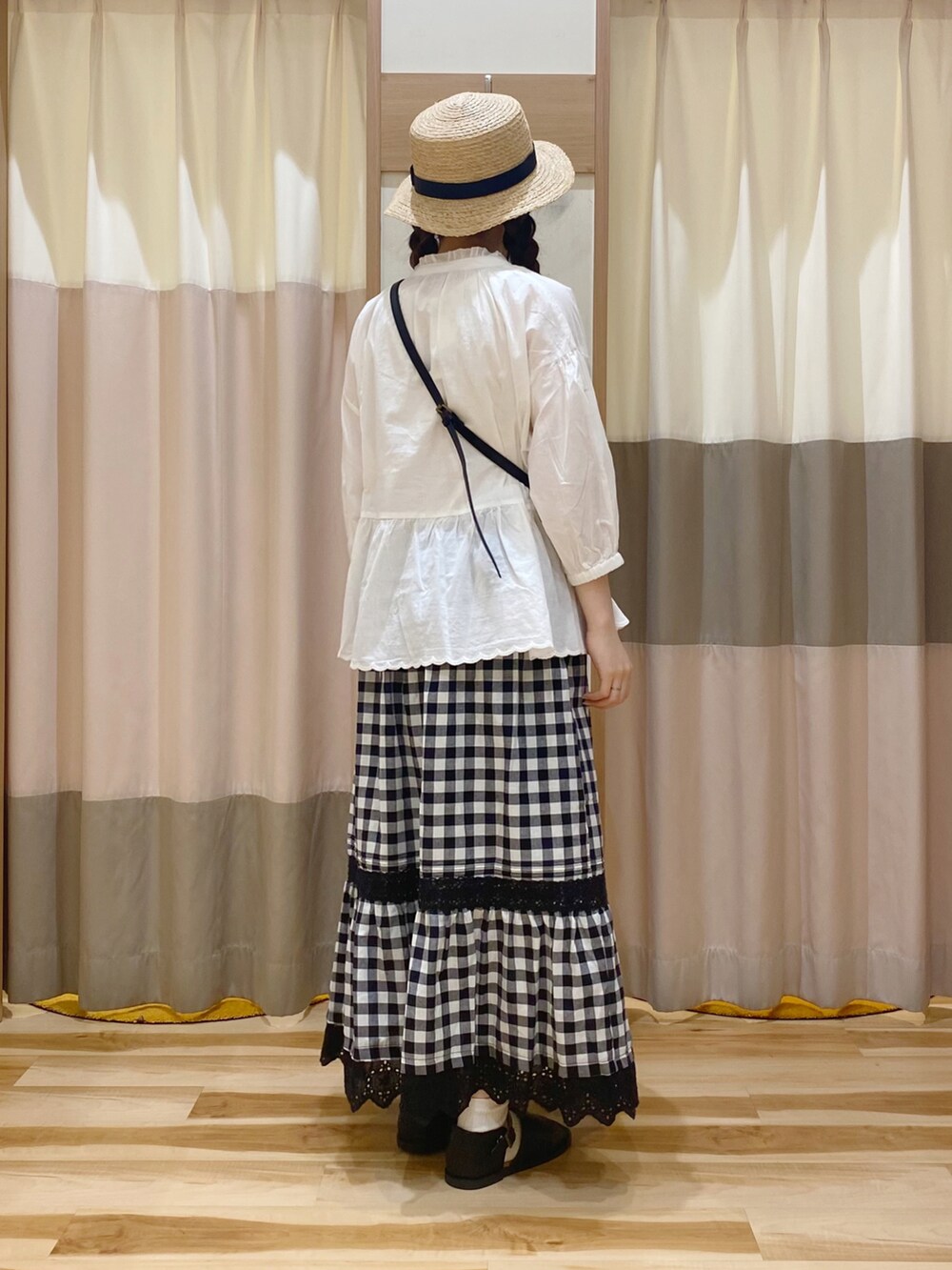 ホワイト系のシャツ/ブラウス、ホワイト系のタンクトップ、ブラック系のスカートを着用したレディースの夏コーディネートの2枚目の写真