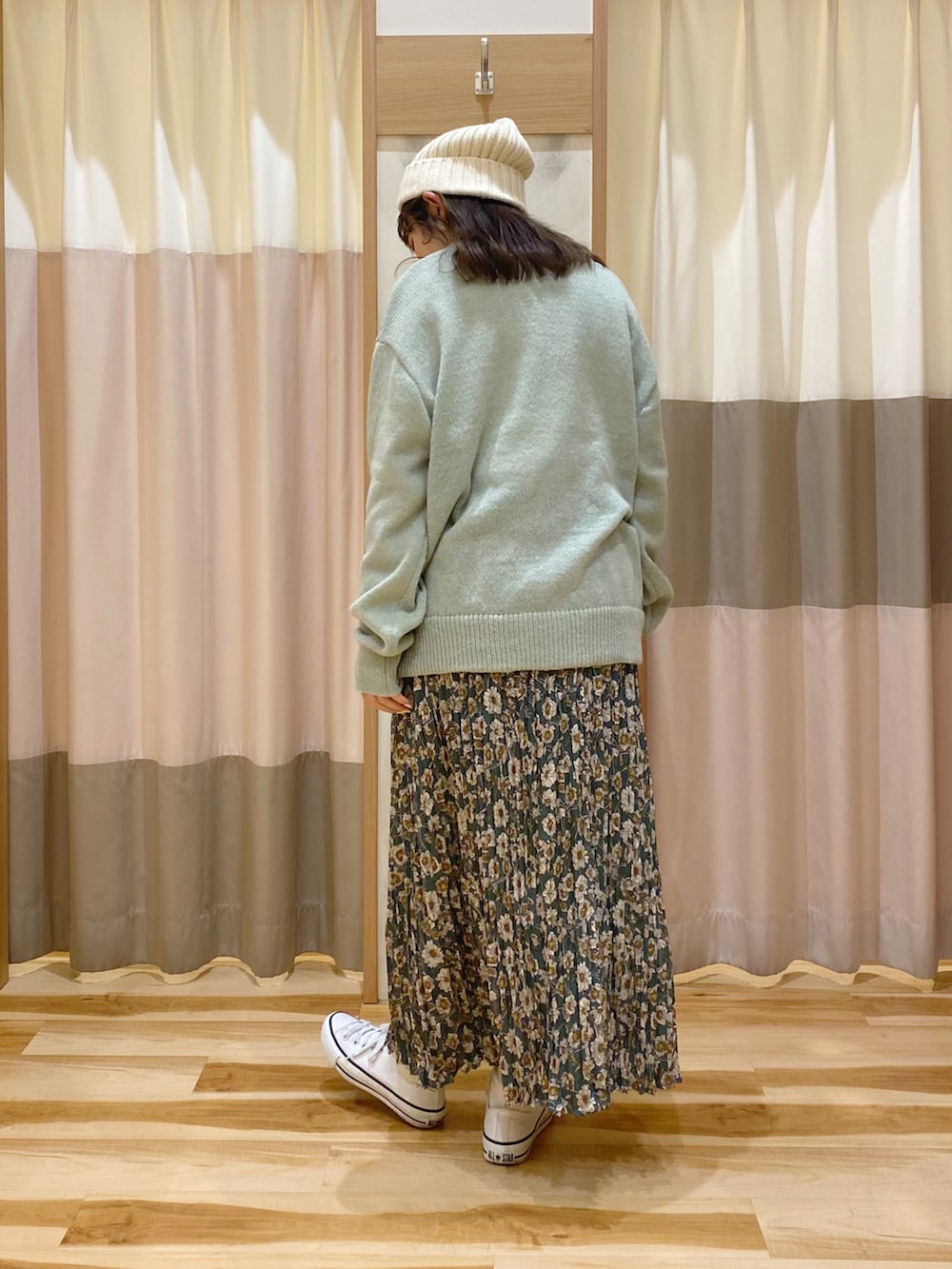 グリーン系のカーディガン/ボレロ、ホワイト系のシャツ/ブラウス、グリーン系のスカートを着用したレディースの冬コーディネートの2枚目の写真