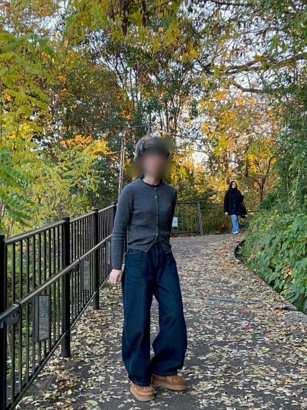 グレー系のカーディガン/ボレロ、ブルー系のデニムパンツ、ブラック系のキャップを着用したレディースの冬コーディネートの2枚目の写真