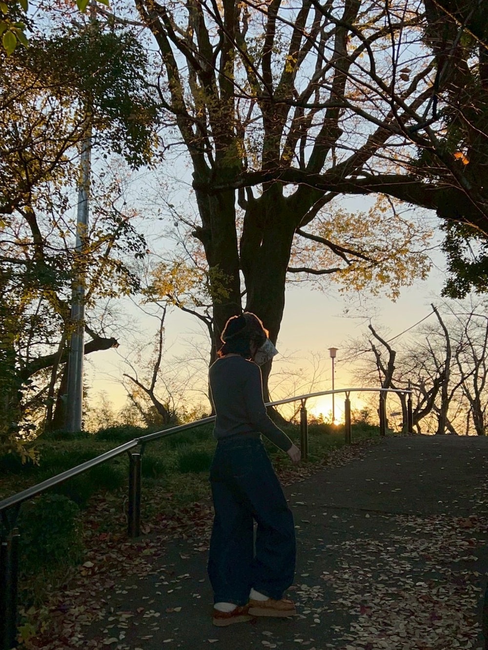 グレー系のカーディガン/ボレロ、ブルー系のデニムパンツ、ブラック系のキャップを着用したレディースの冬コーディネートの3枚目の写真