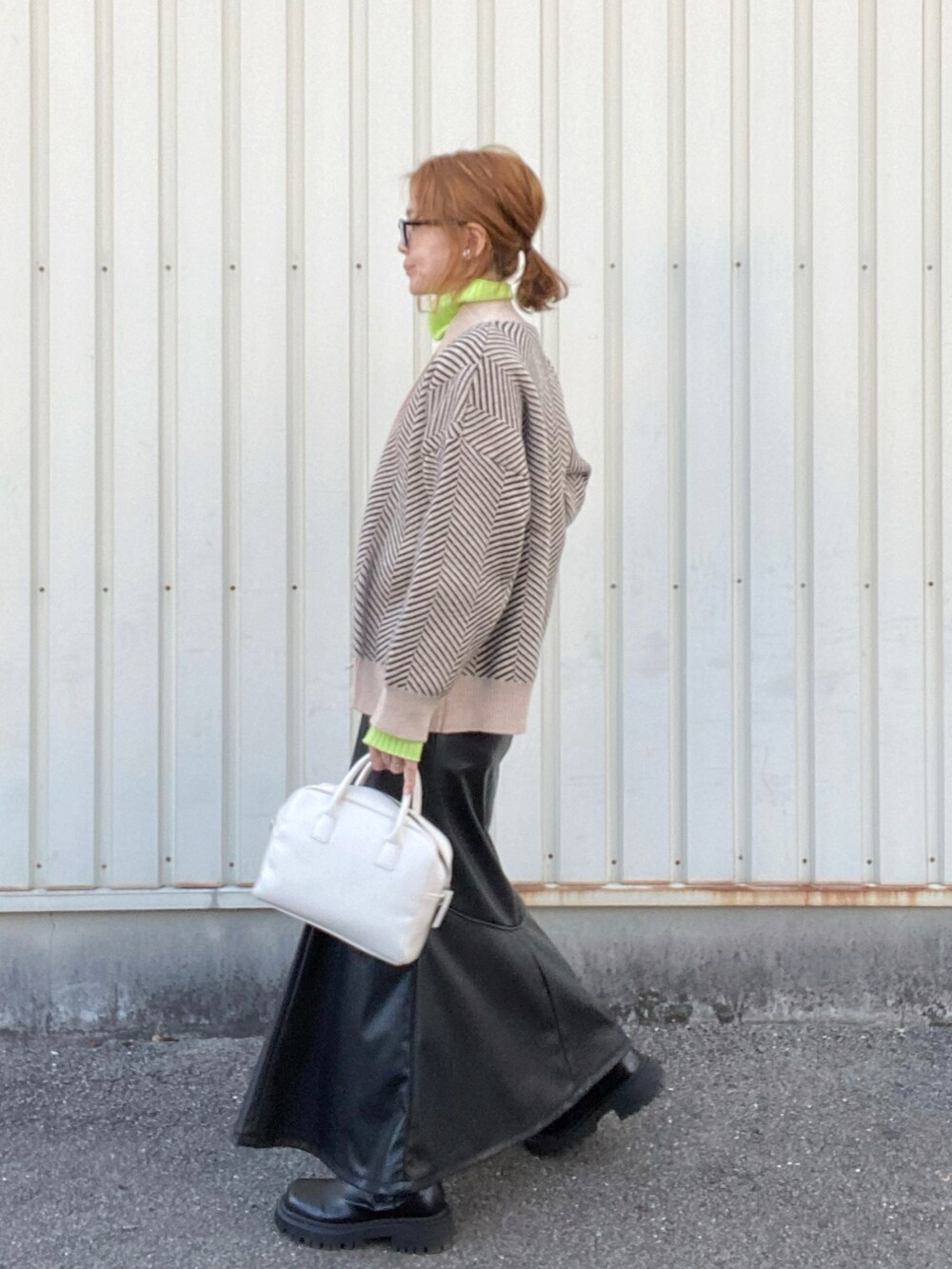 ブラック系のカーディガン/ボレロ、グリーン系のニット/セーター、ブラック系のスカートを着用したレディースの冬コーディネートの2枚目の写真