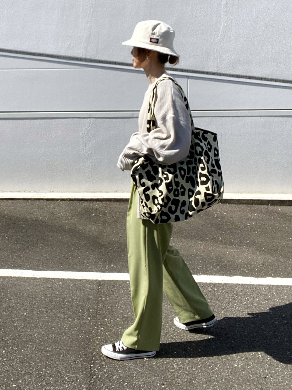 ベージュ系のニット/セーター、グリーン系のその他パンツ、ブラック系のトートバッグを着用したレディースの春コーディネートの4枚目の写真