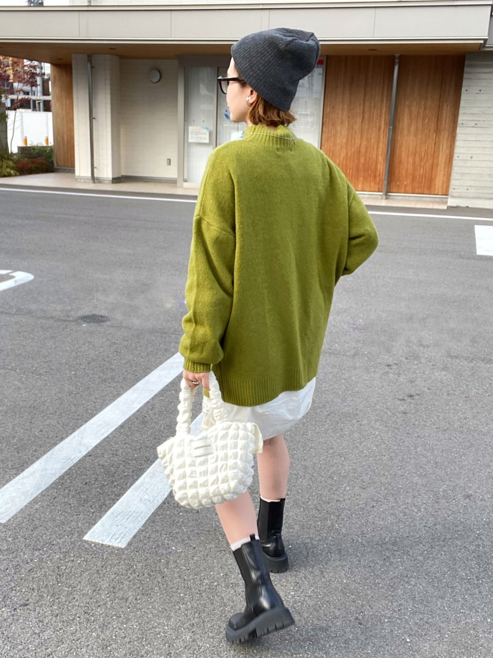 グリーン系のニット/セーター、ブラック系のブーツ、シルバー系のネックレスを着用したレディースの秋コーディネートの2枚目の写真