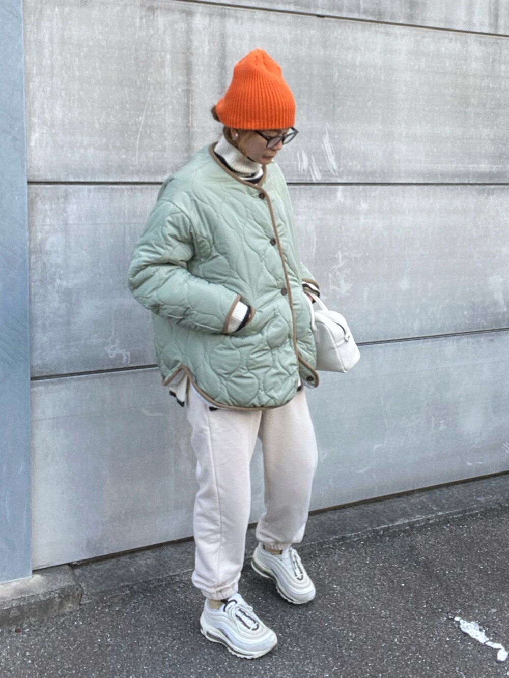ホワイト系のノーカラージャケット、ホワイト系のニット/セーター、ホワイト系のスニーカーを着用したレディースの冬コーディネートの2枚目の写真