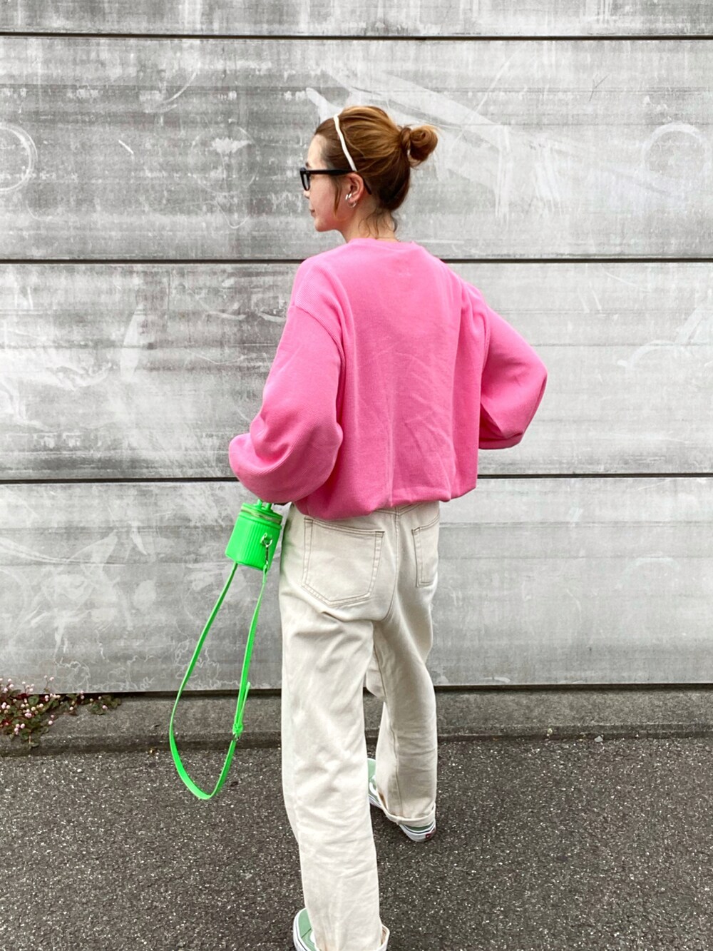 ピンク系のTシャツ/カットソー、ホワイト系のデニムパンツ、グリーン系のスニーカーを着用したレディースの春コーディネートの2枚目の写真