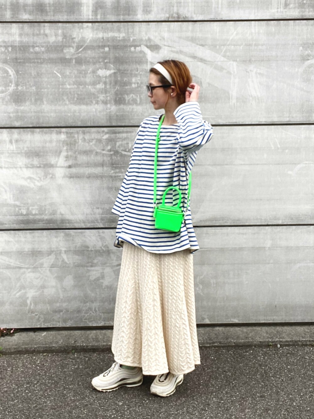 ブルー系のTシャツ/カットソー、ホワイト系のスカート、ホワイト系のスニーカーを着用したレディースの春コーディネートの3枚目の写真