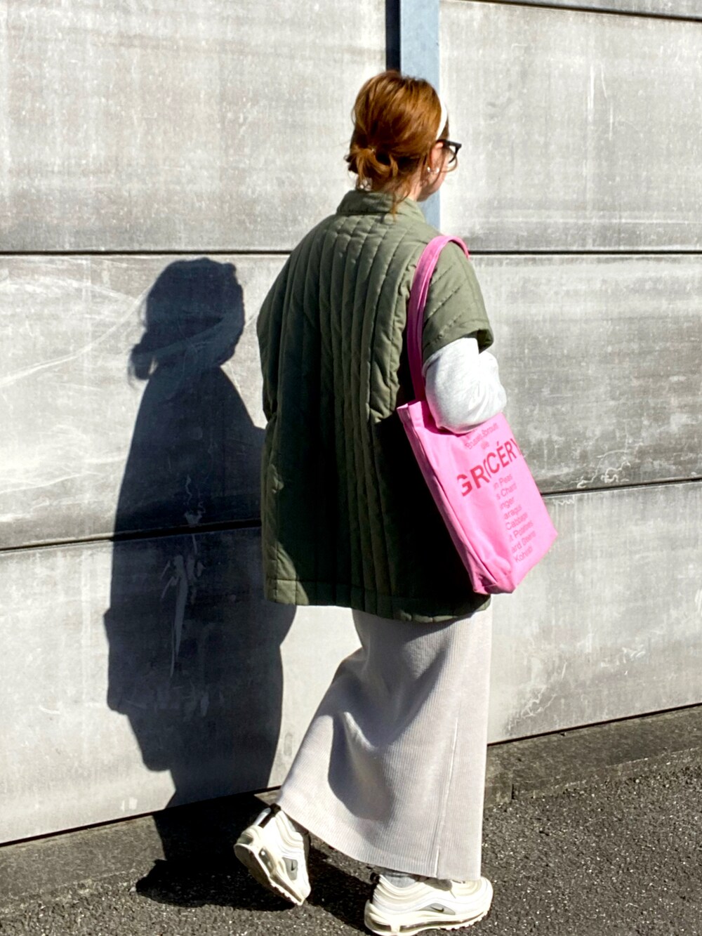 グリーン系のベスト、ベージュ系のスウェット、ホワイト系のスカートを着用したレディースの春コーディネートの4枚目の写真