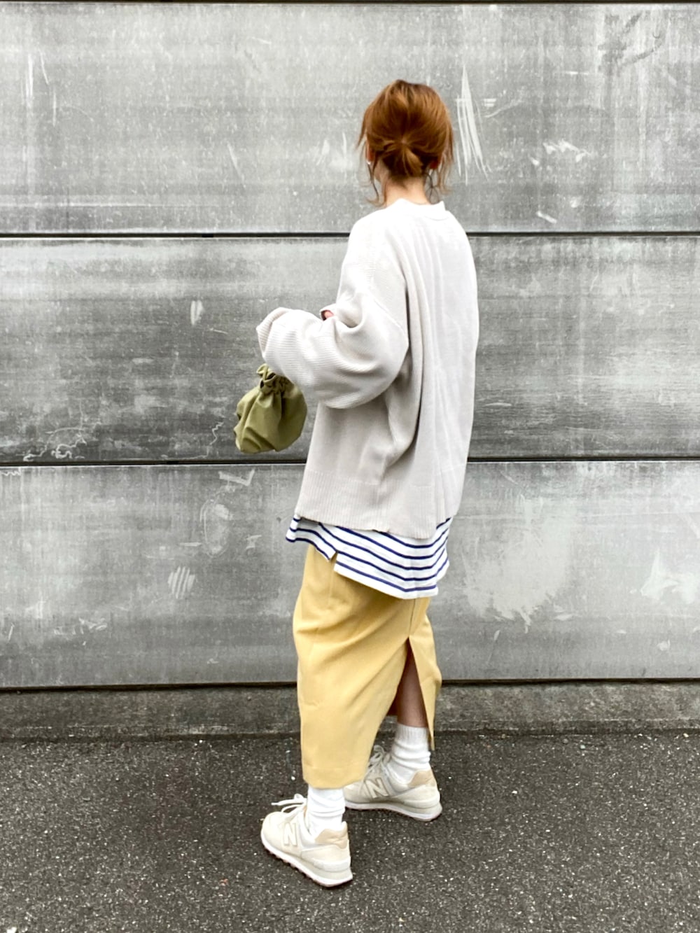 イエロー系のスカート、ホワイト系のカーディガン/ボレロ、ホワイト系のスニーカーを着用したレディースの春コーディネートの2枚目の写真
