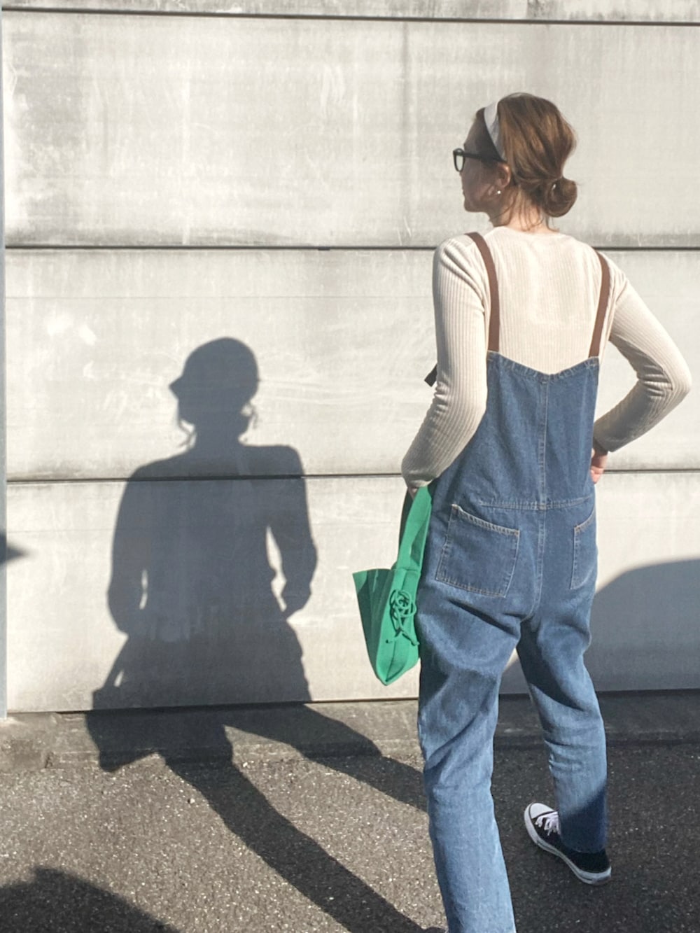 ベージュ系のニット/セーター、グリーン系のトートバッグ、ブラック系のスニーカーを着用したレディースの冬コーディネートの3枚目の写真