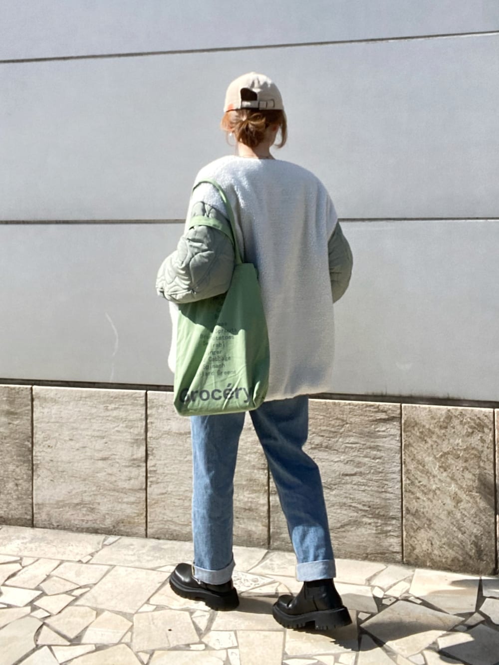 ベージュ系のニット/セーター、ブルー系のパンツ、ブラック系のブーツを着用したレディースの冬コーディネートの4枚目の写真