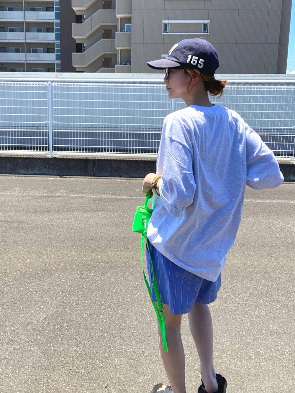 グレー系のTシャツ/カットソー、ブラック系のサンダルを着用したレディースの夏コーディネートの2枚目の写真