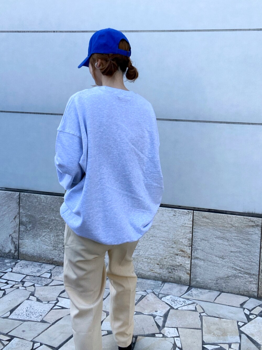 イエロー系のスラックス、ブラック系のボストンバッグ、ブラック系のローファーを着用したレディースの春コーディネートの3枚目の写真