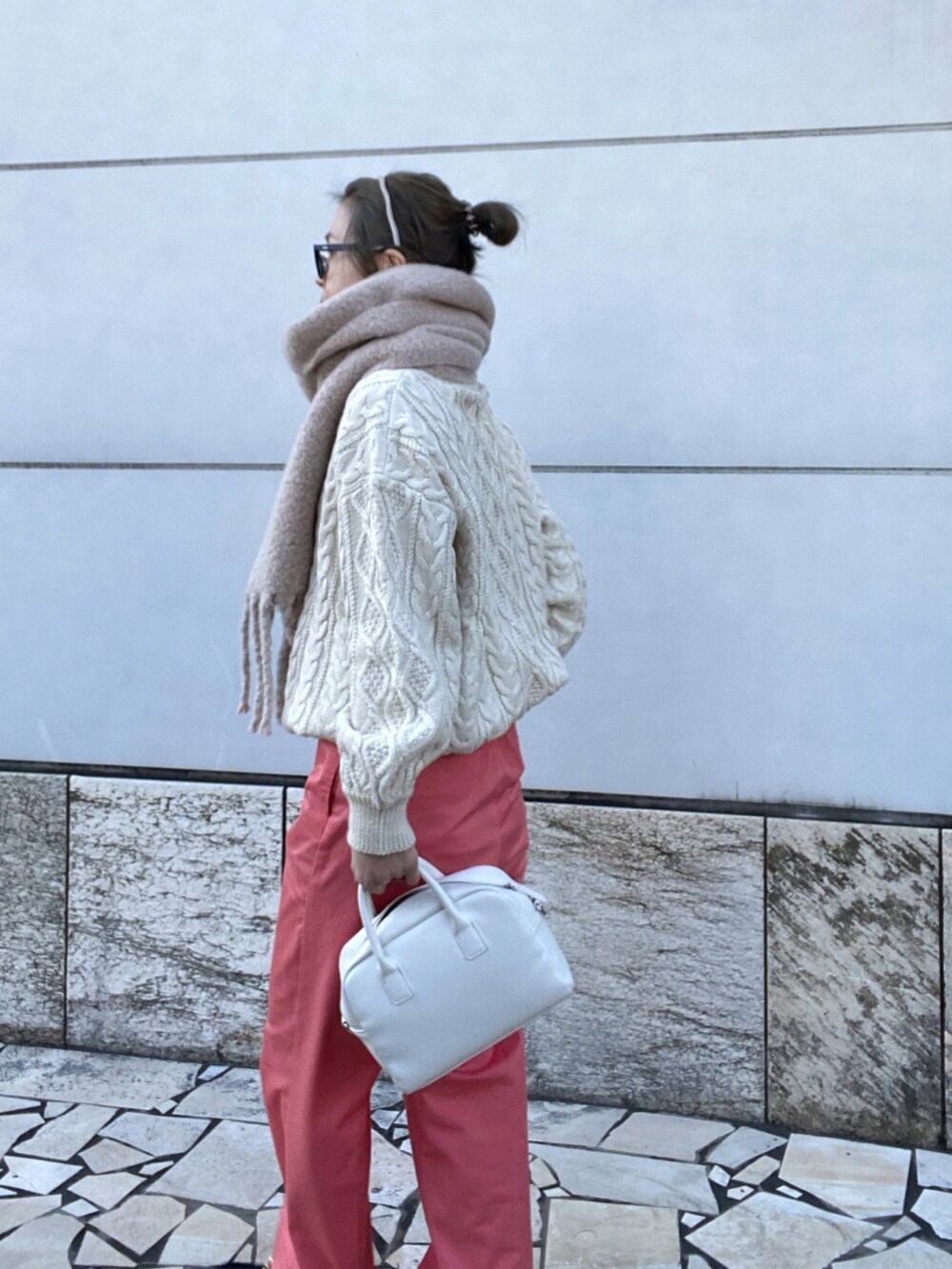 ピンク系のチノパンツ、ホワイト系のニット/セーター、ホワイト系のボストンバッグを着用したレディースの冬コーディネートの3枚目の写真
