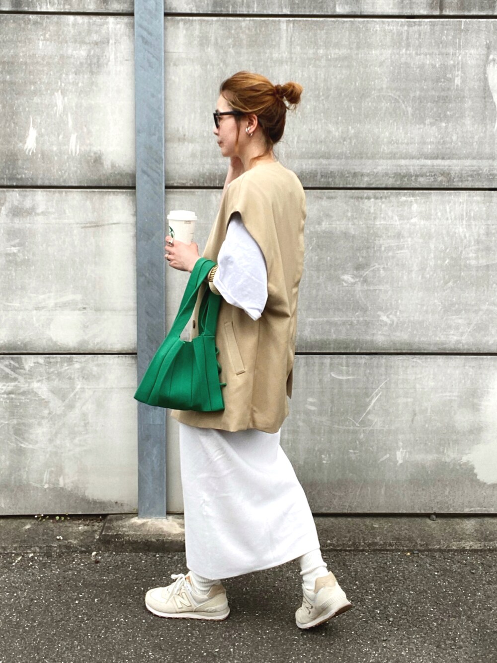 ベージュ系のベスト、ホワイト系のTシャツ/カットソー、ホワイト系のスカートを着用したレディースの春コーディネートの3枚目の写真