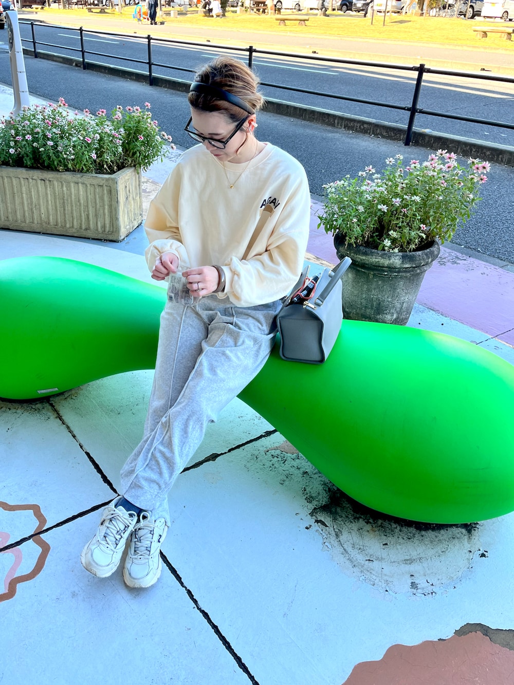 グレー系のその他パンツ、ホワイト系のスニーカーを着用したレディースの秋コーディネートの2枚目の写真