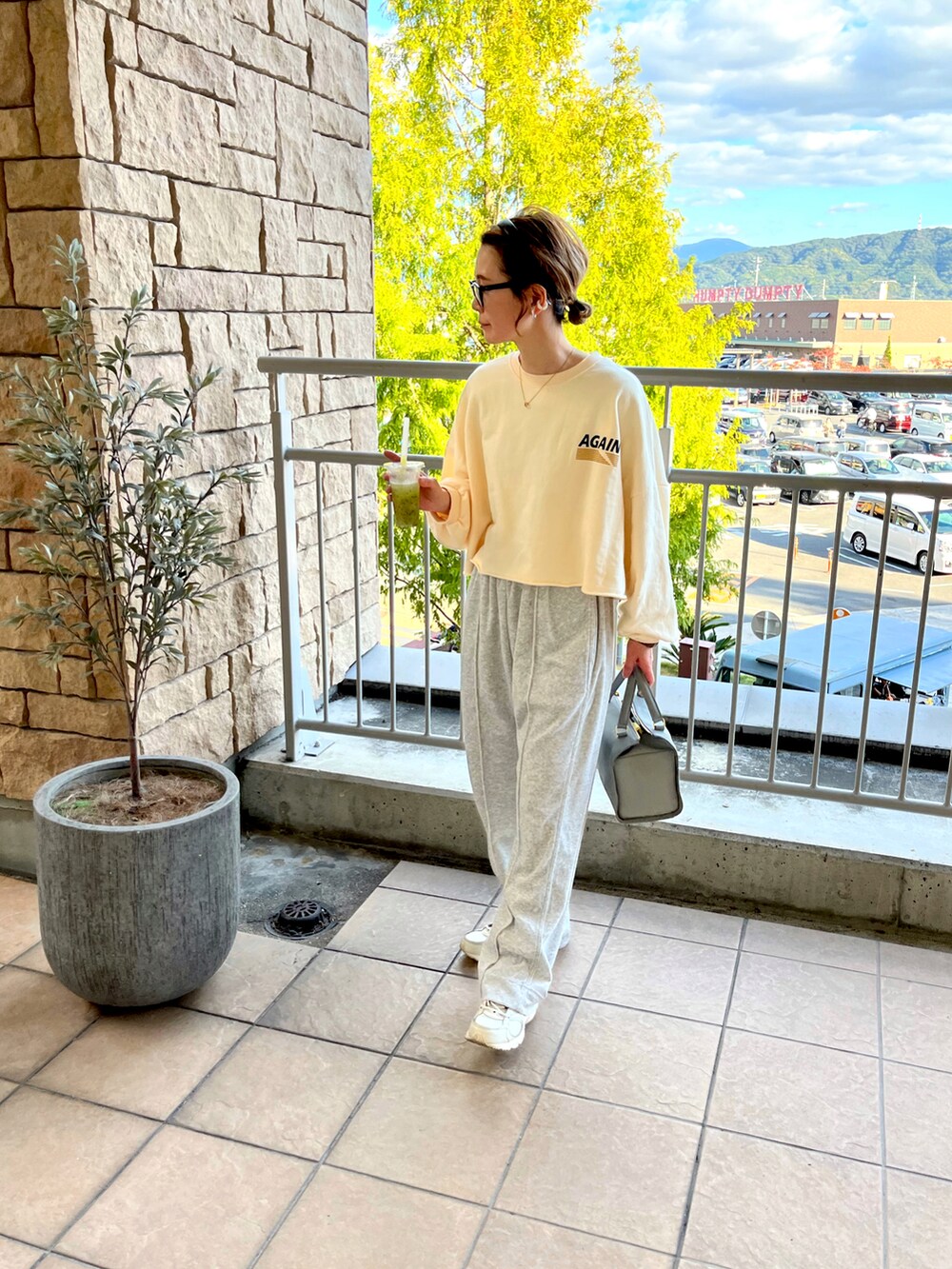 グレー系のその他パンツ、ホワイト系のスニーカーを着用したレディースの秋コーディネートの3枚目の写真