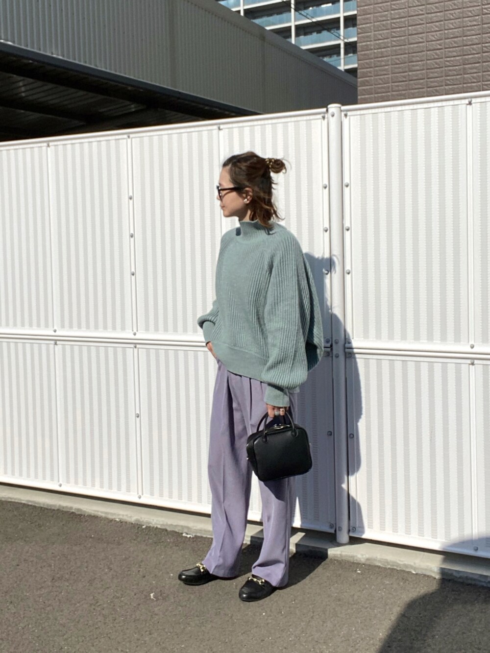 ブルー系のニット/セーター、ブラック系のボストンバッグ、ブラック系のローファーを着用したレディースの秋コーディネートの2枚目の写真