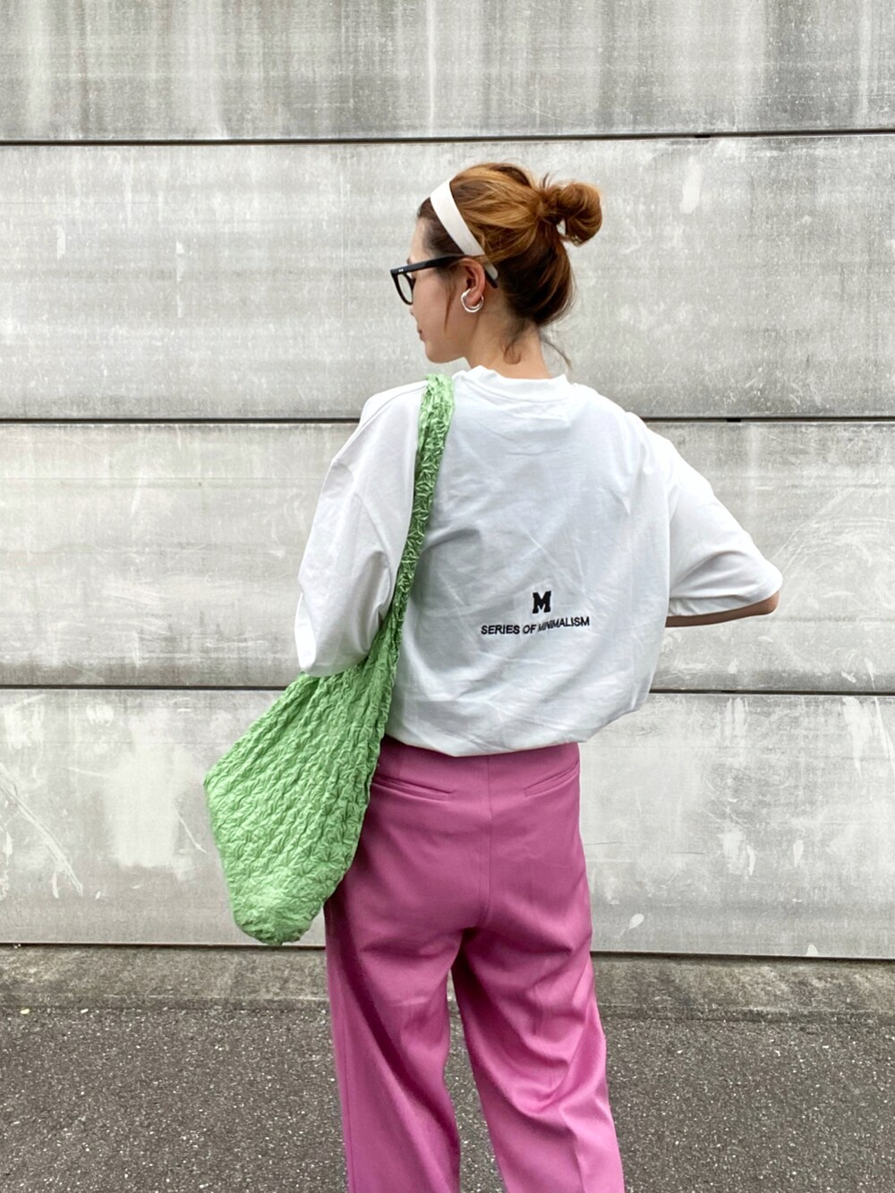 ピンク系のスラックス、ホワイト系のサンダル、ブルー系のトートバッグを着用したレディースの夏コーディネートの3枚目の写真