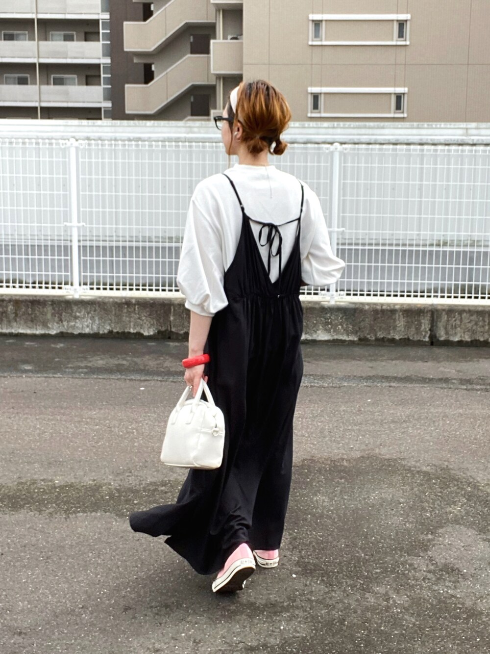 ブラック系のワンピース、ホワイト系のTシャツ/カットソー、ホワイト系のボストンバッグを着用したレディースの春コーディネートの2枚目の写真