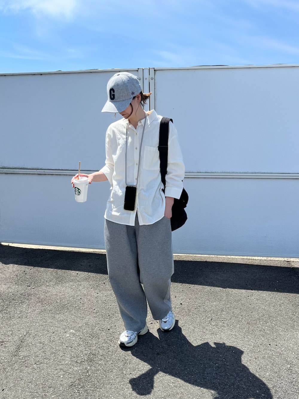 ホワイト系のスニーカー、グレー系のキャップを着用したレディースの春コーディネートの2枚目の写真