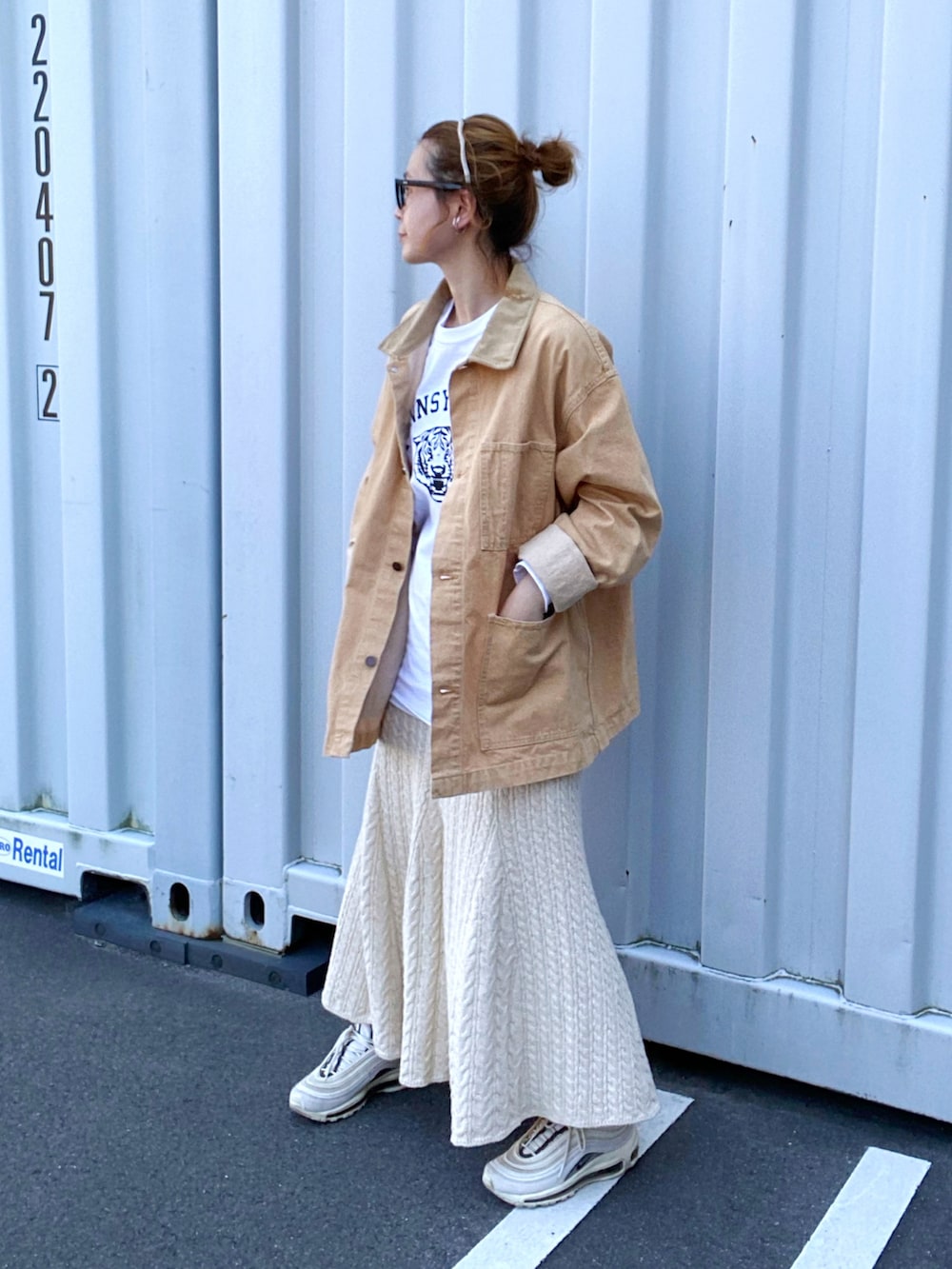 ホワイト系のTシャツ/カットソー、ホワイト系のスカート、ホワイト系のスニーカーを着用したレディースの春コーディネートの2枚目の写真